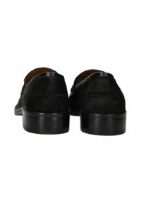 Coppia di scarpe eleganti nere in pelle viste da dietro con tacchi bassi e texture liscia su sfondo bianco.