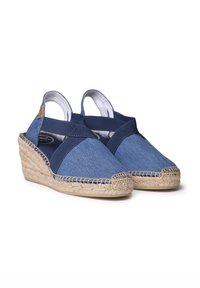 Džínové espadrilové wedges s křížovými námořnickými popruhy, detaily z jutového lana a kulatou špičkou. Obsahují polstrovanou stélku a šikmý podpatek.