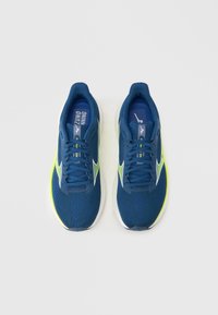 Μπλε παπούτσια τρεξίματος με πλέγμα υλικό, λευκές και λαχανί λεπτομέρειες, υφή επιφάνειας και μαύρη καουτσούκ σόλα. Διαθέτουν κορδόνια και λογότυπο.
