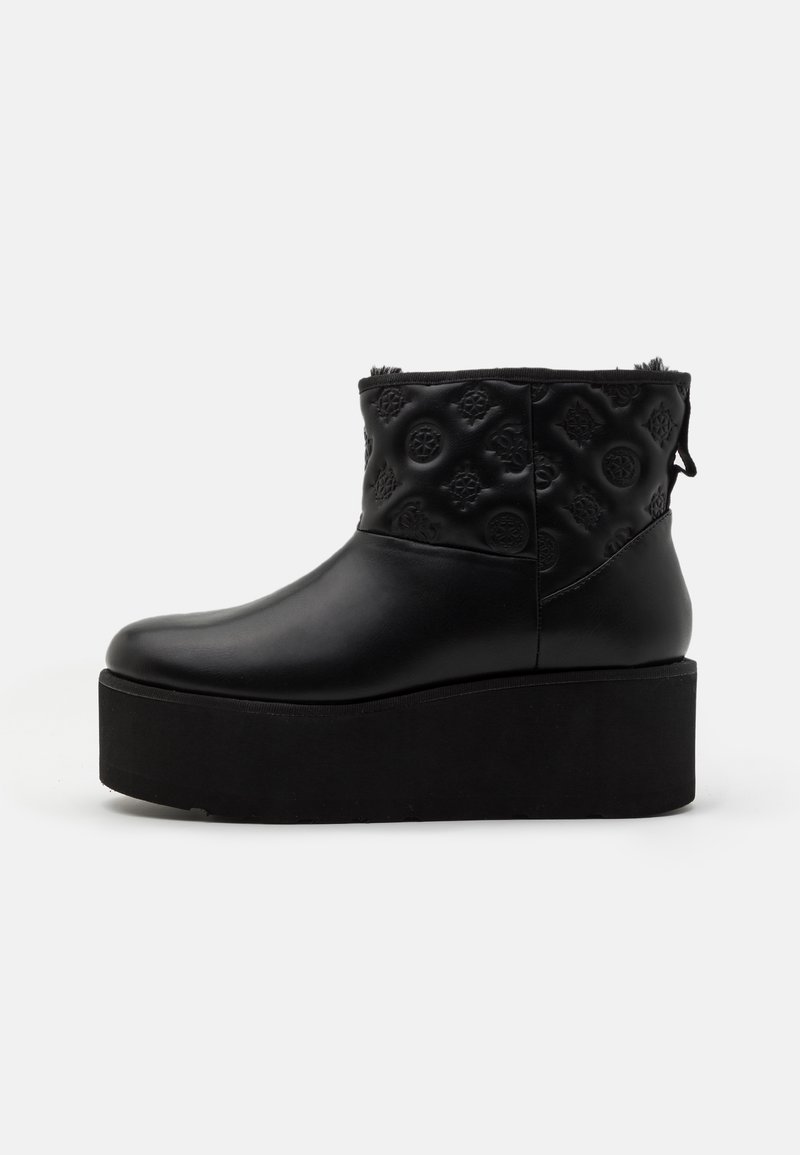 Bottine noire à plateforme avec motifs floraux embossés sur la partie supérieure et une semelle épaisse, vue de profil gauche.