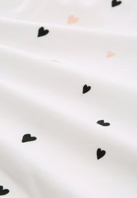 Biała tkanina o gładkiej fakturze, z rozproszonymi małymi wzorami serc w kolorze czarnym i różowym.