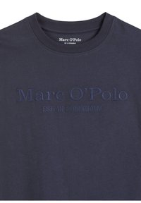 Navyblauw T-shirt met korte mouwen, gemaakt van zachte katoen. Bevat geborduurd merk "Marc O'Polo EST. IN STOCKHOLM" op de voorkant.
