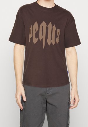 Bruin katoenen T-shirt met een grote, gestileerde "pequs"-afbeelding in een lichtere bruine kleur aan de voorkant. Ronde halslijn en korte mouwen.