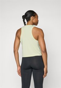 Light green, sleeveless crop top with a rounded neckline and racerback design, paired with black leggings; smooth fabric with minimal detailing.