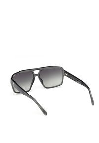 Gafas de sol rectangulares negras con lentes gris degradado, montura gruesa y brazos de templo texturizados. Presentan un diseño geométrico distintivo.