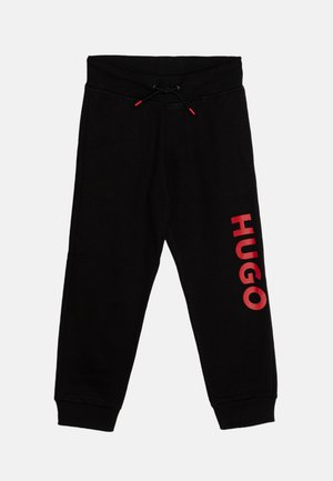 Zwarte sweatpants met een zachte textuur; heeft een rood "HUGO" logo op het linkerbeen en een elastische tailleband met een trekkoord voor een verstelbare pasvorm.