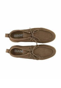 Brune ruskindsko med rund tå, snøreb�ånd og en tekstureret gummisål. Har en lille hælflap og prægede brandlogo indeni.