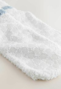 White, textured fabric with a soft, fuzzy surface featuring raised circular patterns. Smooth edges and subtle coloration detail.