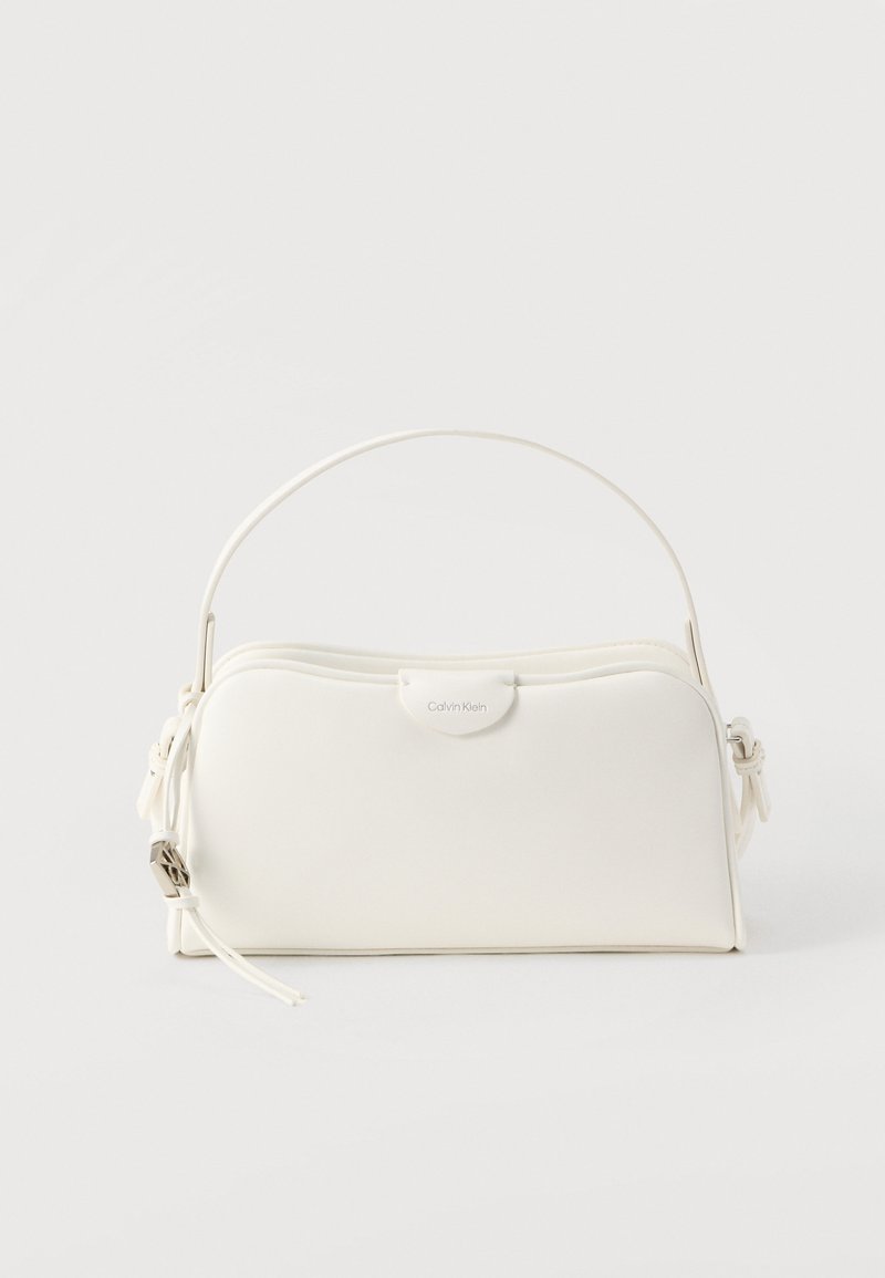 Sac à main blanc avec une texture lisse, une forme arrondie, un design structuré, une poignée supérieure et un discret logo de marque sur le devant.