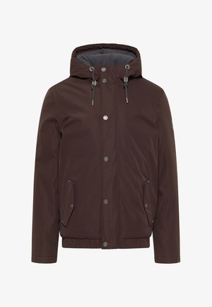 Barna vízálló dzseki kapucnival, fémből készült snap gombokkal, állítható zsinórokkal, oldalsó zsebekkel és elasztikus mandzsettákkal. Simább textúra.