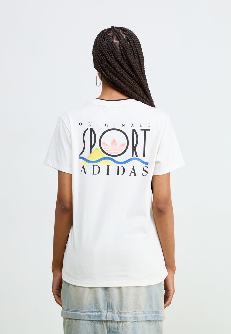 Hvit bomull t-skjorte med stort grafisk trykk på baksiden som har "ADIDAS," "SPORT," og et fargerikt design av bølger og sol.