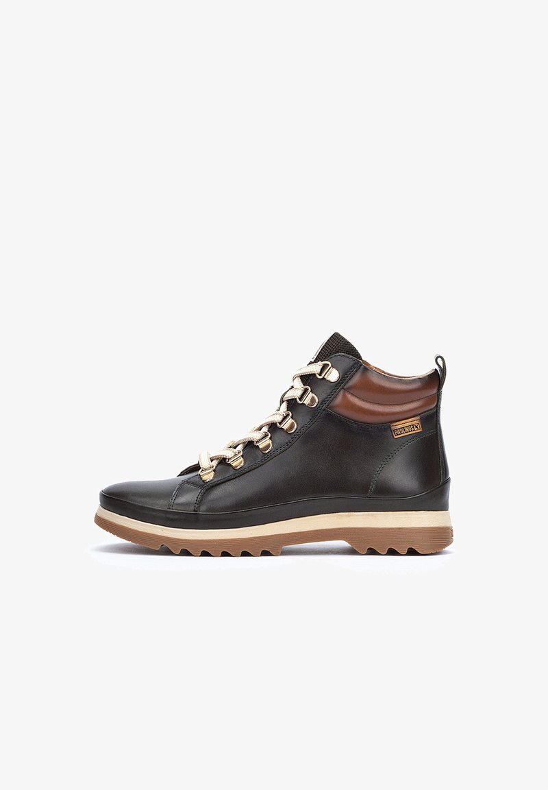 Botas de tobillo de cuero en negro con un acento marrón; presentan ojales dorados, una lengüeta texturizada y una suela de goma con un patrón de tacos.