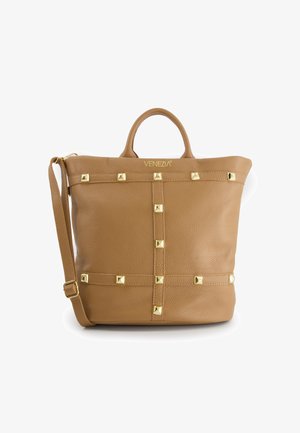 Tasche aus tanfarbenem Leder mit goldfarbenen Nieten, die in einem Gittermuster angeordnet sind, doppelten oberen Griffen und einem verstellbaren Schultergurt. Sichtbares "VENEZIA"-Logo.