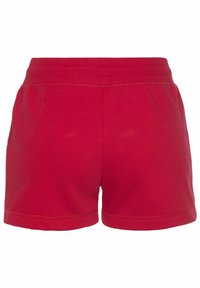 Red cotton shorts with an elastic waistband, featuring a simple design, hemmed edges, and a smooth texture. No pockets visible.