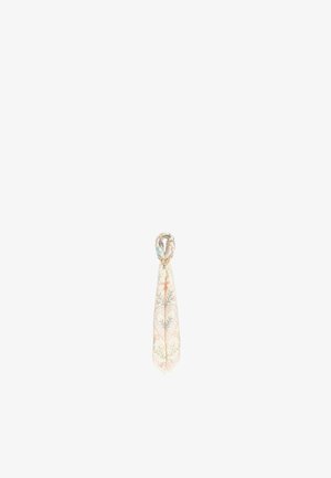 Pañuelo de seda de color claro con estampado, atado con un pequeño anillo dorado en forma de corazón en el centro.