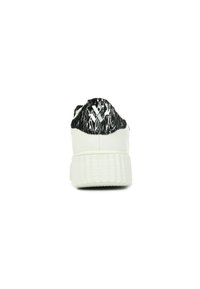 Sneaker bianco con una tomaia in tessuto nero e bianco testurizzato, caratterizzato da una suola spessa e scanalata. Il design include un sottile accento del logo.