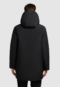 Black puffer coat with a high collar and oversized hood. Features a smooth texture and long sleeves, with side zippers at the hem.