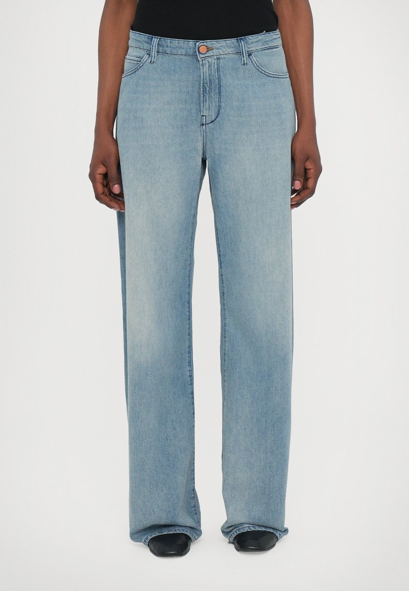 Ljust blå vida jeans i denim med knappstängning och framfickor. De har en något blekt finish och rak passform.