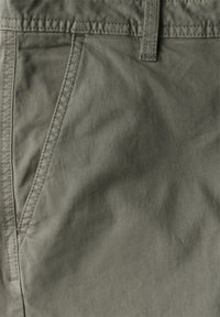 Kalhoty z bavlněné směsi v olivově zelené barvě, s elastickým pasem a bočními kapsami, s hladkým, texturovaným povrchem a jemnými švy.