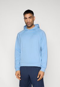 Sweat à capuche bleu clair avec une poche frontale, des manches raglan, et une capuche à cordon. Présente un petit logo sur la poitrine. Texture de tissu douce.