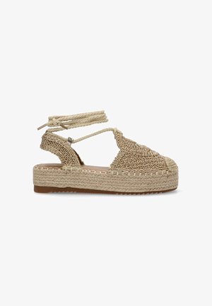 Sandalia espadrille beige con parte superior de tela tejida, tiras de cuerda entrecruzadas y suela plataforma envuelta en yute. Plantilla de cuero suave.