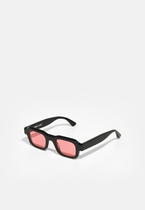 Black square sunglasses with pink lenses, thick plastic frame, and straight arms. Brand name displayed on the side.