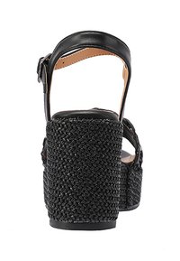 Sandali con tacco a cuneo neri con piattaforma intrecciata nera, cinturino alla caviglia in pelle liscia e fibbia regolabile. Materiale texturizzato sul tacco per una migliore presa.