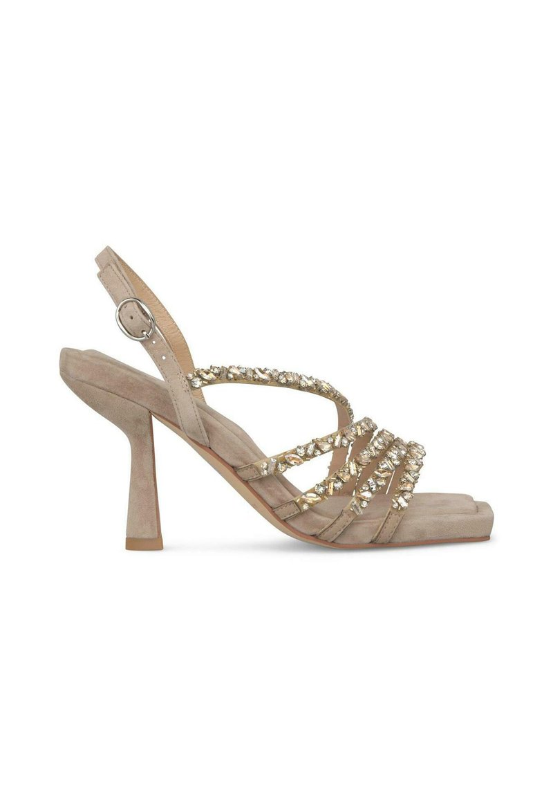 Sandalias de tacón alto de ante beige con un tacón bloque, con tiras entrecruzadas adornadas con embellishments metálicos. Diseño de punta abierta.