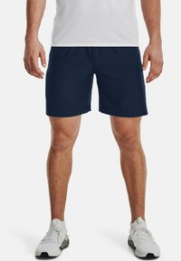 Pantalones cortos azul marino hechos de una tela suave, con un corte recto y una banda elástica en la cintura. Combinados con zapatillas deportivas blancas.