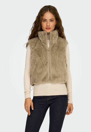 Taupe nepleren vest met hoge kraag en ritssluiting. Voorzien van een verstelbare trekkoord aan de onderkant en gelaagd over een beige top.