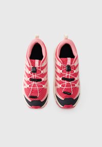Sport shoes in pink and cream with mesh upper, elastic laces, and black accents. Features a loop tab at the heel for easy wear.