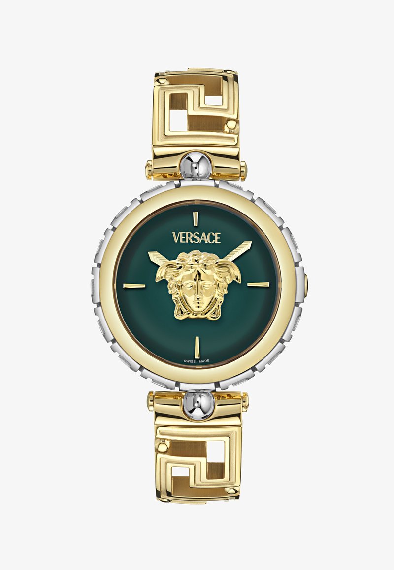 Kulla ja hõbedane käekell rohelise dialsiga, millel on Medusa motiiv, ümmargune korpus ja geomeetriline muster kuldsel käevõral.