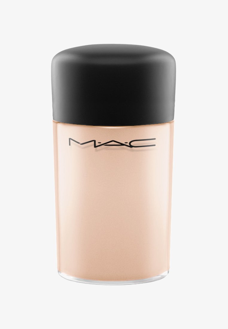 Fondotinta MAC in una bottiglia cilindrica di vetro satinato con un tappo di plastica nera. La bottiglia è beige, con una superficie liscia e un branding minimale.