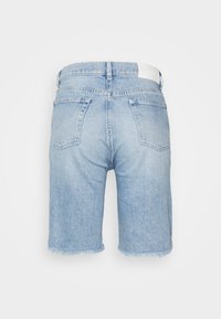 Vaaleansiniset farkkushortsit, joissa on rispaantunut helma, viisi taskua ja vyötärötarramerkki. Kangas on hieman haalistuneen näköinen.