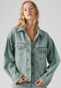 Lichtblauwe denimjack met een klassiek ontwerp, voorzakken, knoopsluiting en een relaxte pasvorm met een licht vervaagde textuur.