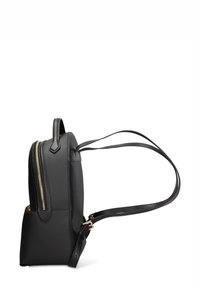 Zaino in pelle nera dal design sottile, con cerniera dorata e spallacci regolabili, forma strutturata e dettagli minimalisti.