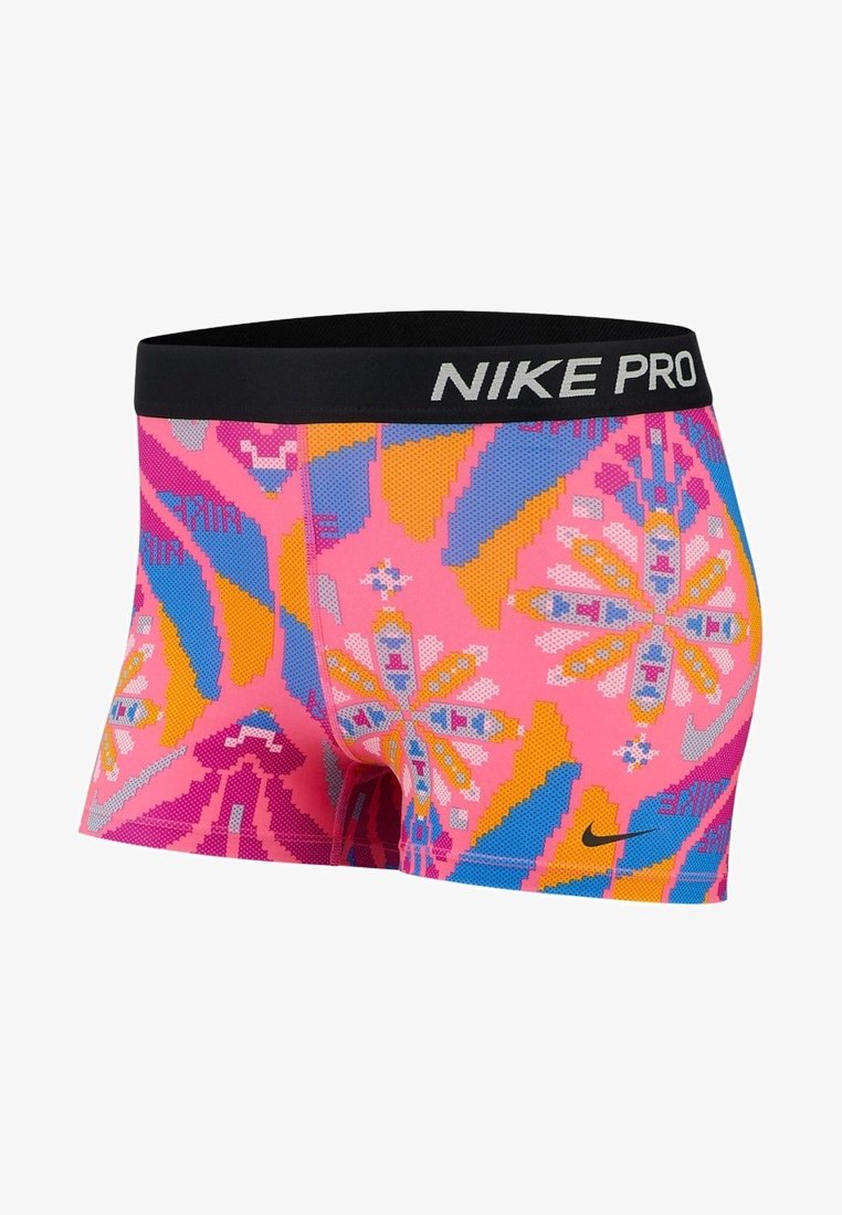 Shorts Nike Pro pour femmes en rose vif avec des motifs floraux géométriques bleus, orange et violets et une ceinture noire avec le logo blanc Nike Pro.