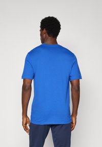 Kortærmet blå T-shirt lavet af bomuld, med et klassisk crew neck-design og en glat tekstur, med minimale syninger.