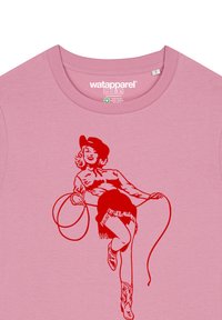 Roze katoenen t-shirt met een rode grafische illustratie van een vrouw met een lasso, die een cowboyhoed en franjes draagt, met korte mouwen.