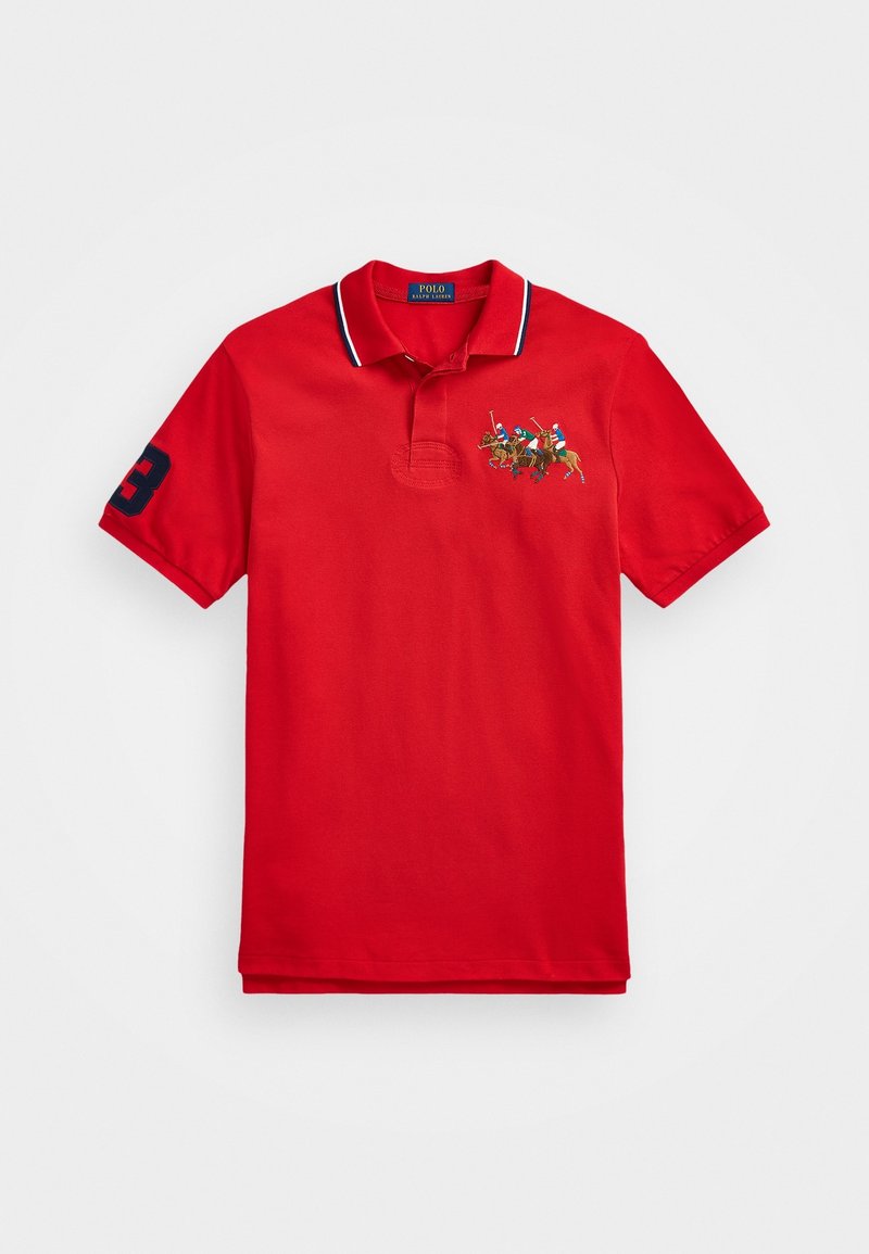 Polo shirt rouge avec col, présentant une scène de polo multicolore brodée sur la poitrine et un numéro '3' marine sur la manche.