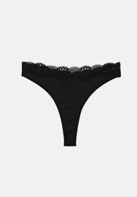 String noir avec une ceinture en dentelle festonnée et un corps en tissu lisse sur un fond uni.