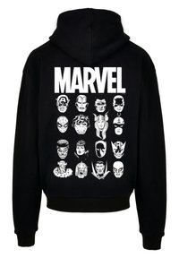 Black hoodie featuring a white "MARVEL" logo and 16 stylized superhero faces in two columns. Material appears soft with a relaxed fit.
