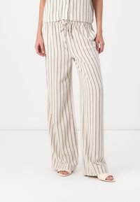 Pantalons évasés en mélange de lin, couleur crème avec des rayures verticales bleu marine. Comprend une taille élastique avec un cordon de serrage pour un ajustement réglable.