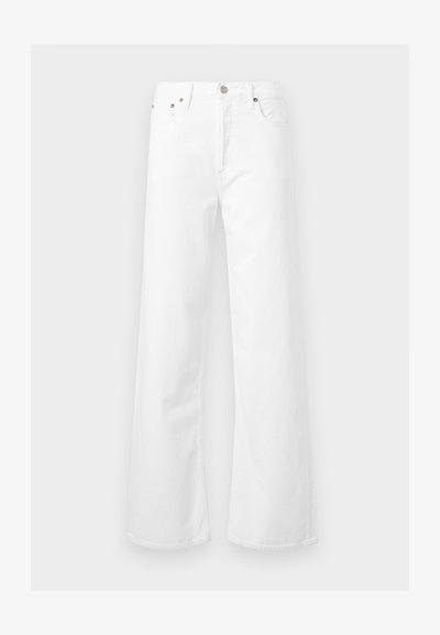 Άσπρο τζιν με ψηλή μέση και φαρδιά μπάτζια, με κούμπωμα κουμπιού και φερμουάρ μπροστά και πεντάτσεπη σχεδίαση σε ανοιχτό γκρι φόντο.