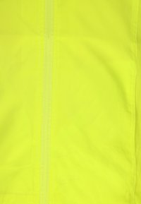 Fluorescerende gul stof med en glat tekstur og lodret søm. Let, holdbart materiale velegnet til synlighed i lavt lys.