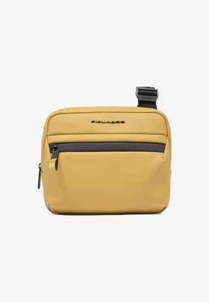 Gelbe synthetische Umhängetasche mit glatter Textur, ausgestattet mit einer vorderen Reißverschlusstasche und einem schwarzen Riemen. Logo deutlich sichtbar.