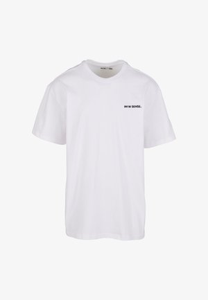 Fehér pamut póló rövid ujjakkal, kerek nyakkal és egy kis fekete szöveges logóval a bal mellrészen. Tiszta, minimalista dizájn.