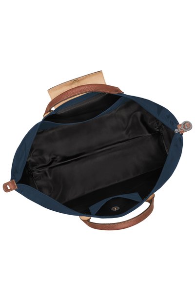 Navy fabric bag with a brown leather strap and interior. Features a black lining, a magnetic closure, and a compartmentalized structure.