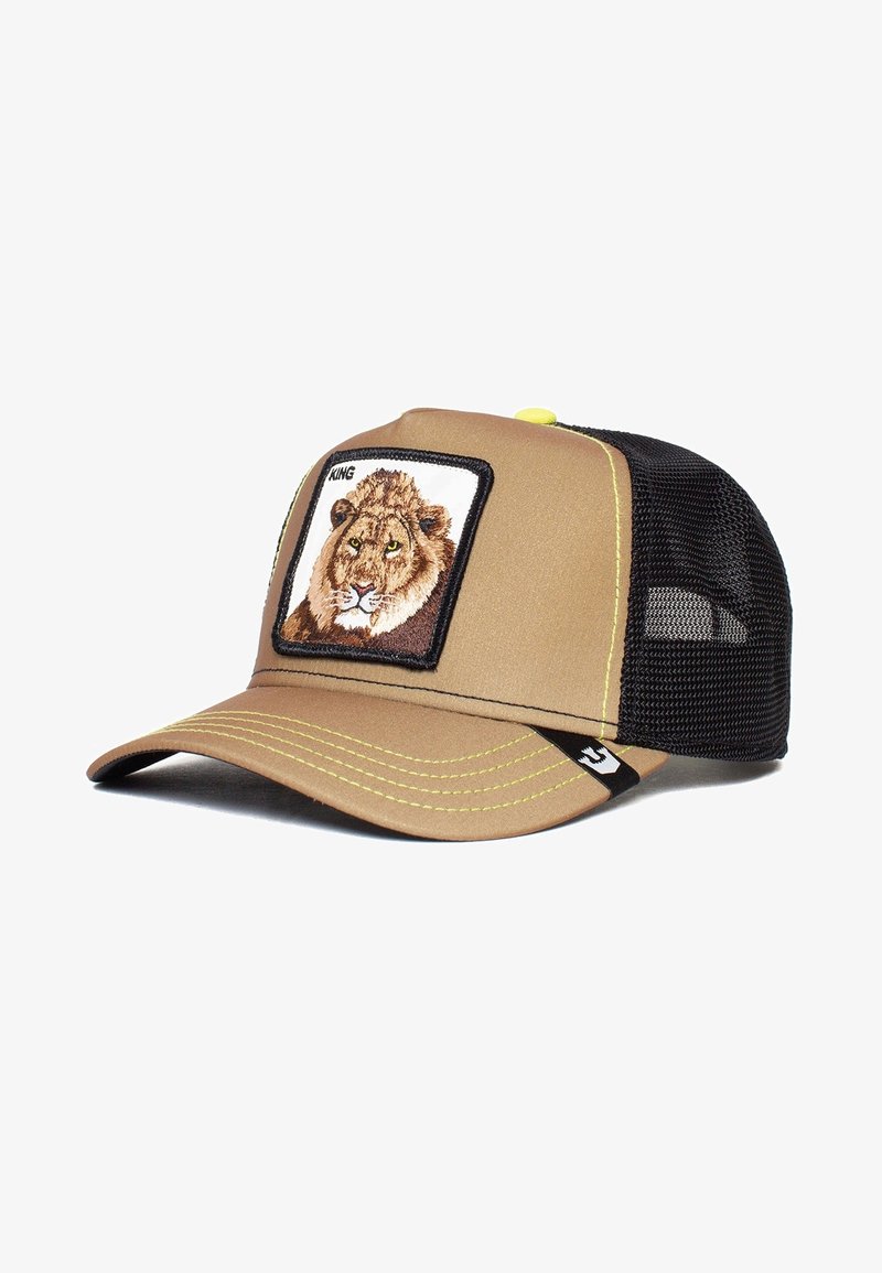Casquette trucker en mesh beige et noir avec un patch lion étiqueté "KING" sur le panneau avant et des surpiqûres jaunes sur la visière.