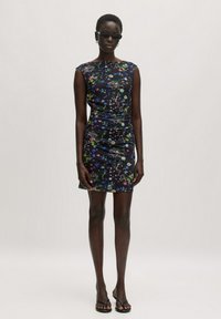 Kurzes Kleid mit Blumenmuster aus dunkelblauem Stoff, figurbetontes Design mit Raffung, ärmellos, ergänzt durch minimalistische schwarze Sandalen und Sonnenbrille.